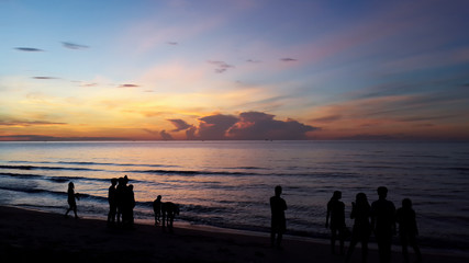 Fototapeta premium Silhouette of people taking picture of landscape during sunrise Scenic View Of Beach Against Sky During Sunset.