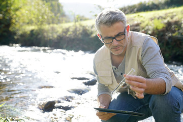 Biologist testing water quality of river