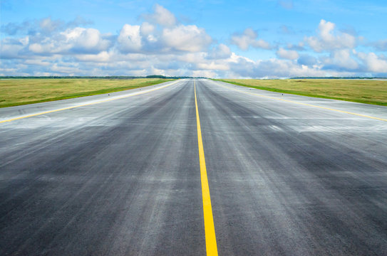 Asphalt road runway with a dividing strip in the horizon.