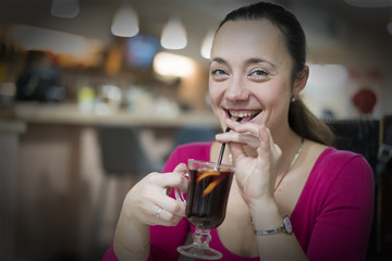 Beautiful smiling woman holding mug of hot drink (apple tea, mulled wine). Female hands with cup of seasonal hot drink. Homemade. toned