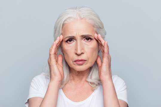 Upset, Sad, Pretty, Nice, Attractive Woman Having Head Ache, Stress, Troubles, Touching Temples With Fingers, Looking At Camera, Standing Over Grey Background