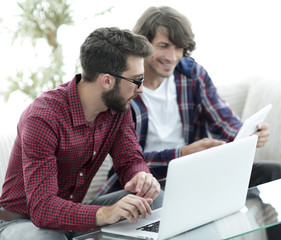 Portrait of two web designers discussing a project in front of a laptop