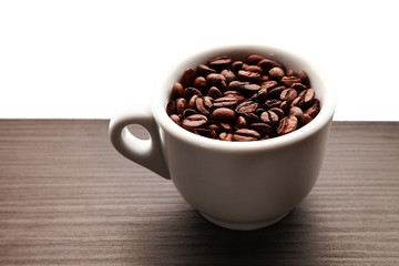 Coffee beans in a cup/ Coffee beans in a cup, standing on a wooden table
