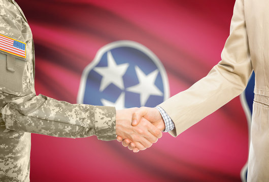 USA military man in uniform and civil man in suit shaking hands with certain USA state flag on background - Tennessee