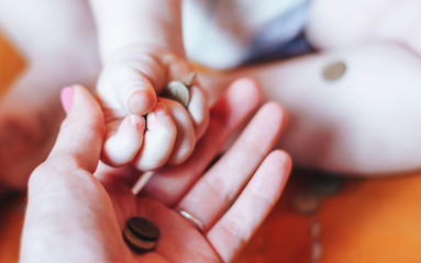 baby gives coins to his mother