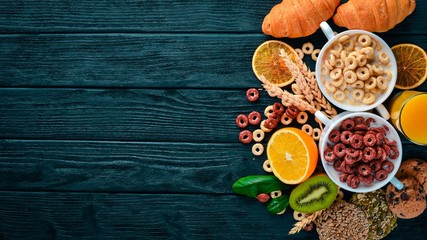 Fitness breakfast, muesli, milk, fruits, nuts and seeds, on a wooden surface. Top view. Free space for text.
