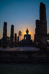 Silhouette of big buddha statue inside ruin temple at Sukhothai Historical Park