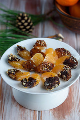 Mandarin in chocolate glaze and nuts on the table