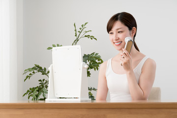美顔器を使う女性、鏡
