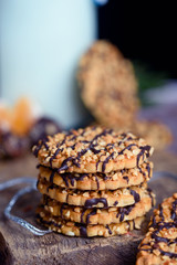 Delicious cookies sprinkled with peanuts on a table with milk and citrus