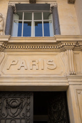 text Paris written on the top of a door of an ancient building in France