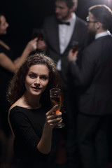 stylish young woman raising a glass of champagne