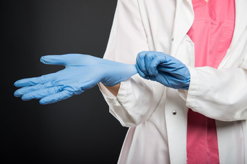 Close-up of doctor putting on her sterile gloves