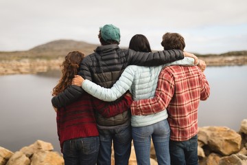 Group of friends standing standing with arms around 