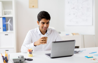 businessman with laptop drinking coffee at office
