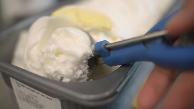 Close Up milk and Lemon plomber Ice Cream Scooping Out Of Container to a Cone