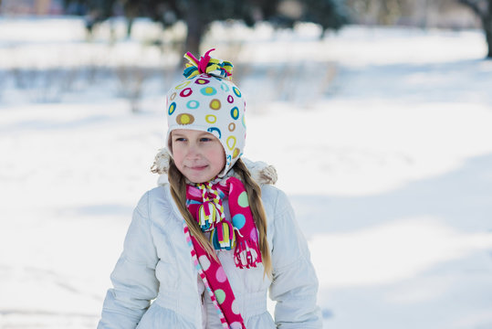 little girl in warm clothing outdoor in winter park