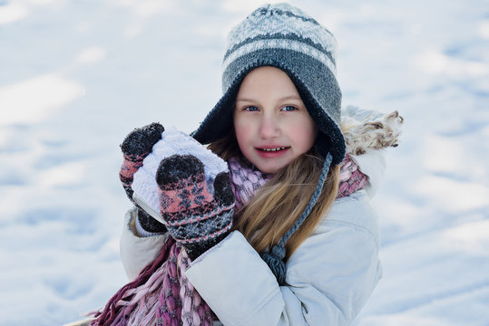 Little girl holds hot cup of tea outdoor. Winter time