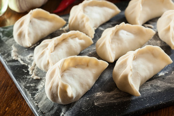Fototapeta na wymiar Raw gyoza or jiaozi dumplings ready for cooking