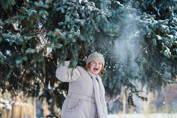 Positive plus size curvy woman plays in snow at winter park