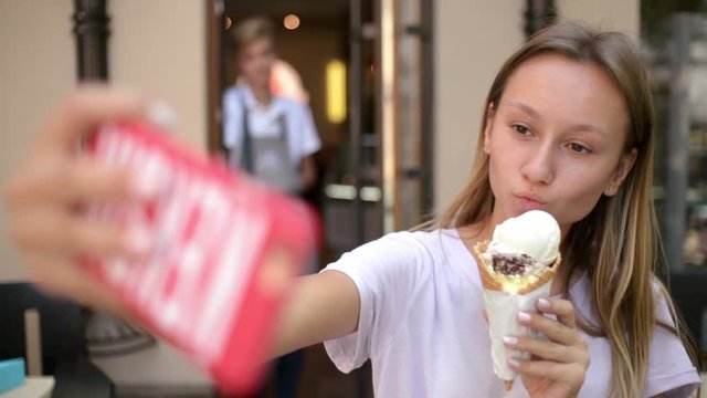 Girl with Ice Cream Cone make Selfie Photo with Smart Phone on the Day Street