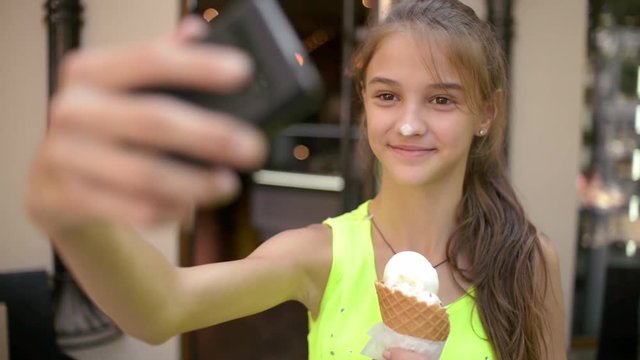 Girl with Ice Cream Cone make Selfie Photo with Smart Phone on the Day Street