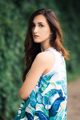 Naklejka premium Sunny positive portrait of sexy stunning girl in short colorful dress having fun on the street