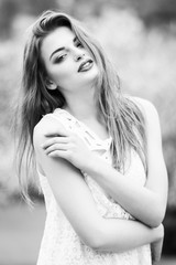 Beautiful woman enjoying sunny spring day in park during cherry blossom season