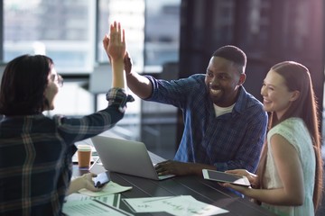 Happy executives giving high five to each other