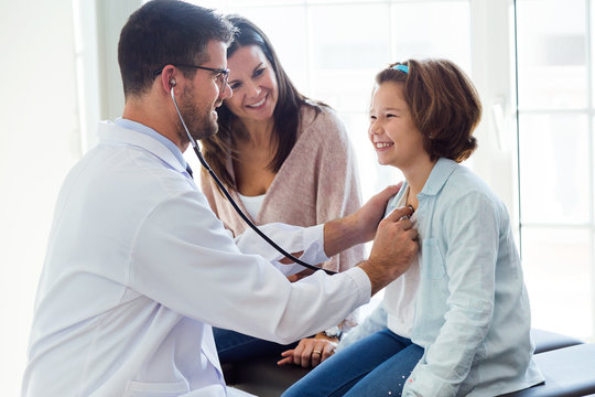Mother with her daughter being examined with stethoscope by pediatrician.