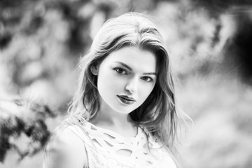 Naklejka premium Beautiful woman enjoying sunny spring day in park during cherry blossom season