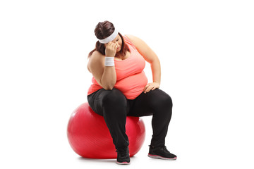 Sad overweight woman sitting on an exercise ball