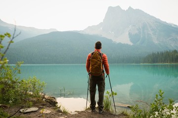 Rear view of hiker standing near lake