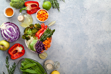 Tasty healthy bowl for lunch with couscous, baked broccoli and carrots cut in cubes, fried peas, avocados and red cabbage. Easy vegetarian diet concept. Rustic background, copy space.