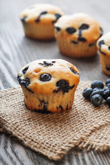 muffin with blueberries on a wooden table. fresh berries and sweet pastries on the board.