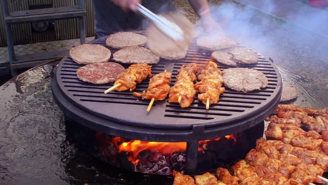 garden barbecue adding hamburger patties