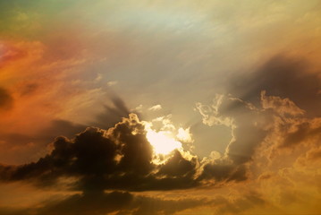 Sonnenstrahlen leuchten durch düstere Wolken hervor und färben den Himmel in atemberaubende Farben
