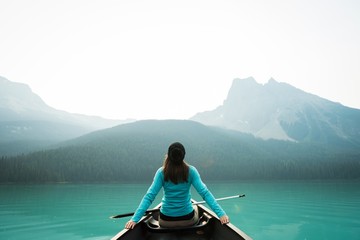 Rear view of woman kayaking in lake