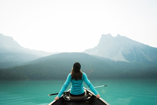 Rear view of woman kayaking in lake