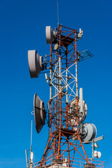 Cell phone relay tower in a bright sunny day. Clear blue sky in the background