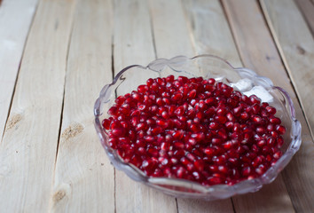 Pomegranate seeds on wooden background
