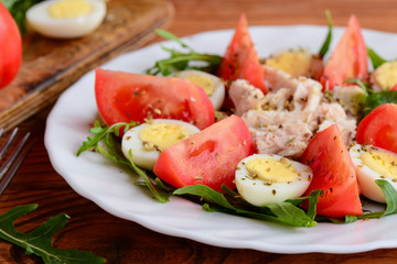 Chicken fillet, tomatoes, quail eggs and arugula salad. Healthy and satisfying salad for lunch or dinner. Closeup