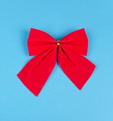 Bright red bow on a bright blue background (minimal concept, top view)