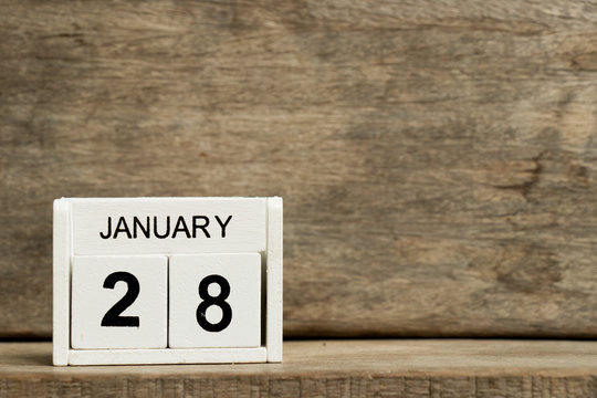 White block calendar present date 28 and month January on wood background