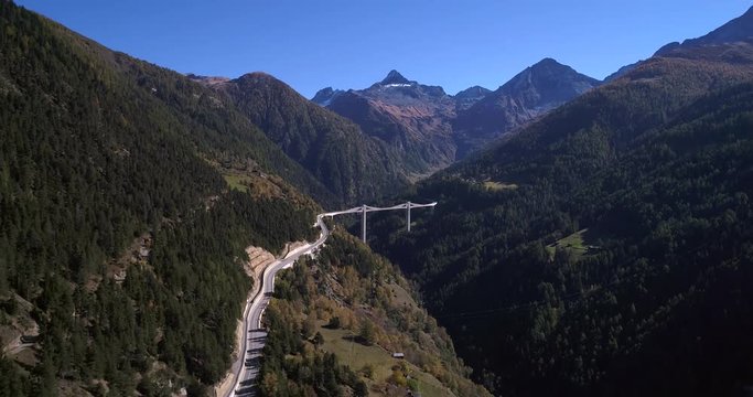 Alpine bridge, Cinema 4k aerial descending tilt view towards a big bridge, between mountains, on a sunny fall day, on simplon pass, in wallis, of the alps in Switzerland