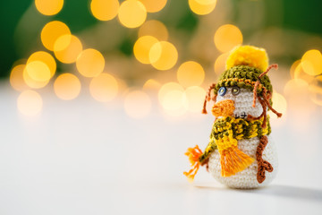 Handmade crochet snowman toy with bokeh