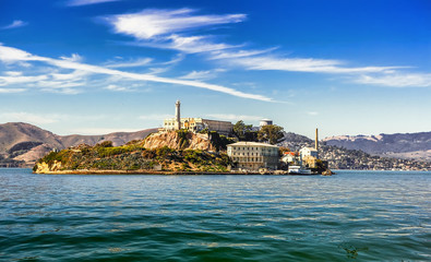 Alcatraz Island and former federal penitentiary on sunny day in San Francisco Bay, California - obrazy, fototapety, plakaty