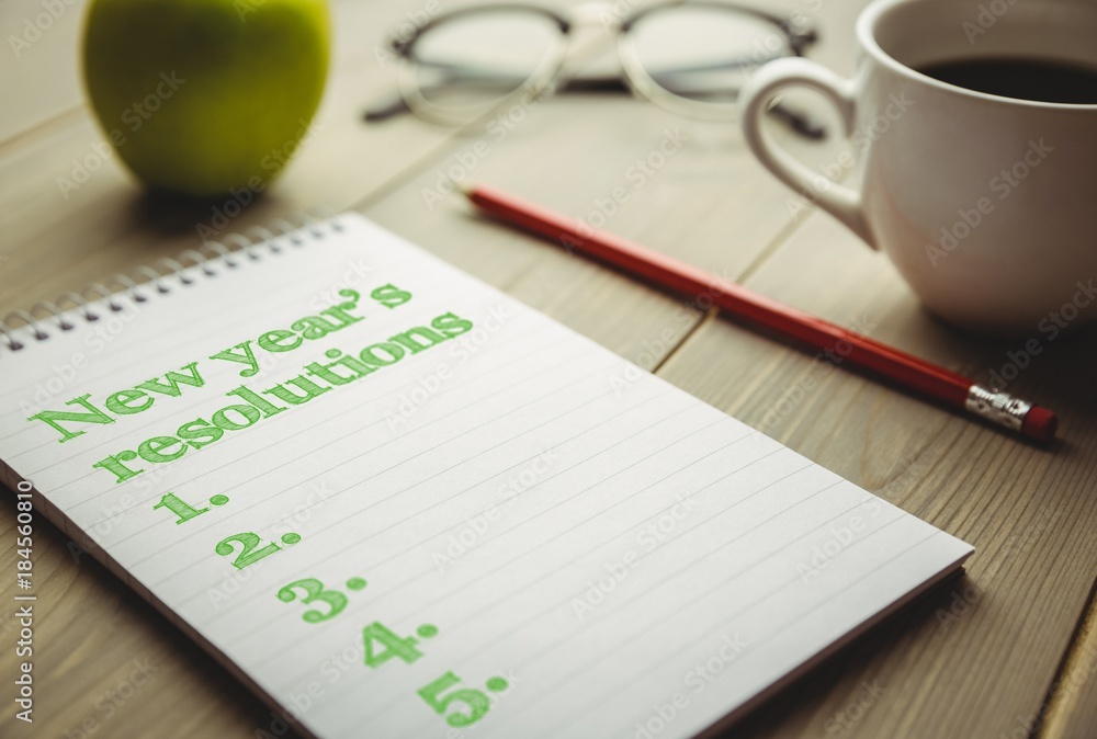 Poster top view of new years resolution written on notepad with pencil and apple on side