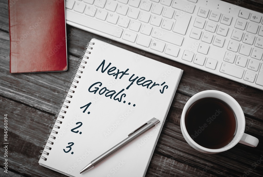Poster top view of new years resolution written on notepad with pen and coffee on side