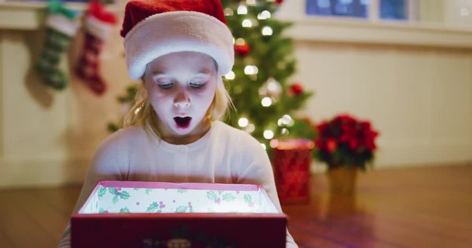 Happy young girl opening amazing Christmas present